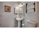 Well-lit bathroom featuring a pedestal sink, decorative mirror and cabinet at 695 Riverwalk Dr. # 101, Myrtle Beach, SC 29579
