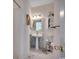 Well-lit bathroom featuring a pedestal sink, decorative mirror and cabinet at 695 Riverwalk Dr. # 101, Myrtle Beach, SC 29579