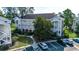 Exterior view of the three-story condo buildings with parking lot and sidewalk at 695 Riverwalk Dr. # 101, Myrtle Beach, SC 29579