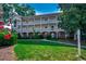 Three-story condominium building with white railings, brick accents, and lush green lawn at 695 Riverwalk Dr. # 101, Myrtle Beach, SC 29579