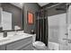 Stylish bathroom with a white vanity, toilet, tub-shower combo, and a dark shower curtain at 752 Hobonny Loop, Longs, SC 29568