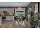 Modern dining area with stylish light fixture, sleek black chairs, and a view to the backyard at 752 Hobonny Loop, Longs, SC 29568