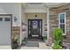Welcoming front entrance with decorative plants, wreath, and stone accents at 752 Hobonny Loop, Longs, SC 29568