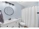 Modern bathroom features a round mirror, shower with curtain, and sleek fixtures and finishes at 83 Reef Run Rd., Pawleys Island, SC 29585