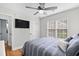 Cozy bedroom features a ceiling fan, TV, and natural light from the window with wood flooring at 83 Reef Run Rd., Pawleys Island, SC 29585