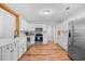 Spacious kitchen featuring white cabinets, stainless steel appliances, and wood-look floors at 83 Reef Run Rd., Pawleys Island, SC 29585
