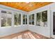 Sun room with wood ceiling and white trim with multiple windows letting in natural light to highlight the wood ceiling at 83 Reef Run Rd., Pawleys Island, SC 29585
