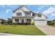 Beautiful two-story home with a covered front porch, well-maintained lawn, and an attached two-car garage at 932 Abernathy Place, Surfside Beach, SC 29575