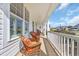 Relaxing front porch view with wicker furniture, white railings, and a glimpse of the neighborhood at 932 Abernathy Place, Surfside Beach, SC 29575