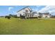 Well-manicured front yard featuring green grass, landscaping, and a charming view of the two-story home at 932 Abernathy Place, Surfside Beach, SC 29575