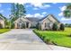 Well-maintained single-story home with a brick facade, manicured lawn, and long driveway at 1009 Maccoa Dr., Conway, SC 29526