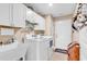 Bright laundry room boasts white cabinetry, utility sink, and modern washer and dryer at 1009 Maccoa Dr., Conway, SC 29526