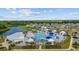 Aerial view of a community pool with cabanas, splash pad, hot tub, lake, and surrounding neighborhood at 1016 Laurens Mill Dr., Myrtle Beach, SC 29579