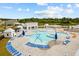 Large resort-style community pool with lounge seating, splash pad, hot tub, cabanas, and lake views at 1016 Laurens Mill Dr., Myrtle Beach, SC 29579