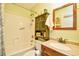 Cozy bathroom features a tub with shower, wood vanity with solid surface, and decorative mirror at 1025 Plantation Dr. # 2413/2414, Little River, SC 29566