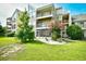 Condo exterior with multiple patios, vibrant landscaping, and lush green lawn at 1025 Plantation Dr. # 2413/2414, Little River, SC 29566