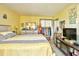 Main bedroom with great light, neutral carpet, decorative wall art, and television set at 1025 Plantation Dr. # 2413/2414, Little River, SC 29566