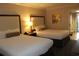 This bedroom boasts two beds with soft white linens and is decorated with neutral, elegant tones at 1105 S Ocean Blvd. # 218, Myrtle Beach, SC 29577