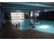 Indoor pool area with swimmers, lounge chairs and large windows at 1105 S Ocean Blvd. # 218, Myrtle Beach, SC 29577