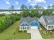 Aerial view of a blue house with a well-manicured front lawn and a two-car garage, surrounded by lush greenery at 117 Black Water Dr., Murrells Inlet, SC 29576