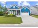 Charming blue home features a well-manicured lawn, covered porch, and two car garage at 117 Black Water Dr., Murrells Inlet, SC 29576