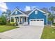 Charming blue home features a well-manicured lawn, covered porch, and two car garage at 117 Black Water Dr., Murrells Inlet, SC 29576