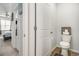 View of a well-lit bathroom with toilet, doorways and view of bedroom with natural lighting at 1301 Camlet Ln., Little River, SC 29566