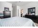 This is a primary bedroom with a light blue comforter, dresser, and view into the kitchen at 1301 Camlet Ln., Little River, SC 29566