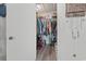 View of the bedroom closet with lots of hanging clothes and a wooden hanging rack at 1311 Turkey Ridge Rd. # A, Surfside Beach, SC 29575