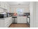 Bright kitchen with stainless steel appliances, white cabinets, mosaic backsplash, and window at 1311 Turkey Ridge Rd. # A, Surfside Beach, SC 29575