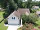 Aerial view of the home with a two-car garage, mature trees, and a well-maintained lawn and landscape at 1409 Ashwood Circle, Surfside Beach, SC 29575