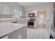 Modern kitchen featuring stainless steel appliances, granite countertops, and white tile flooring at 1409 Ashwood Circle, Surfside Beach, SC 29575