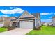 Exterior angle shot featuring a two-car garage, blue siding, white trim, and freshly planted landscaping at 1534 Breakwater Dr., Little River, SC 29566