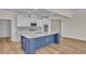 Bright kitchen featuring stainless appliances, white cabinets, an island with sink, and wood-style flooring at 1534 Breakwater Dr., Little River, SC 29566