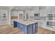 Kitchen with white cabinets, stainless appliances, and large blue island with white countertop; open-concept design at 1534 Breakwater Dr., Little River, SC 29566