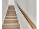 Carpeted staircase with a wooden handrail and white trim at 1534 Breakwater Dr., Little River, SC 29566
