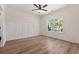 Bedroom with wood accent wall, hardwood floors, ceiling fan, and natural light at 1718 26Th Ave. N, North Myrtle Beach, SC 29582