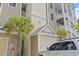 Exterior view featuring a condo building entrance with palm trees and well-maintained landscaping at 181 Ella Kinley Circle # 305, Myrtle Beach, SC 29588