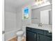 Bathroom with single vanity and sink, a large window, and a tub with shower at 19 Coventry Pl., Pawleys Island, SC 29585