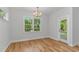 Bright dining room featuring hardwood floors, a modern chandelier, and a view to the outside at 19 Coventry Pl., Pawleys Island, SC 29585