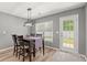 Bright dining room featuring a table with seating for four, a modern light fixture, and a view of the backyard at 276 Whipple Run Loop, Myrtle Beach, SC 29588