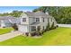 An angled view of a two-story house with a lush lawn, neutral siding, and a two-car garage at 276 Whipple Run Loop, Myrtle Beach, SC 29588