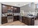 Kitchen view featuring dark cabinets, stainless steel appliances, and granite countertops at 276 Whipple Run Loop, Myrtle Beach, SC 29588