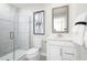 Bright bathroom with modern vanity, framed mirror, and glass enclosed shower with decorative accent tile at 2828 Rowyn St., Longs, SC 29568