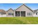 Rear exterior view of home, showcasing the screened-in porch and grassy yard at 347 Leste Rd., Myrtle Beach, SC 29588