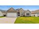 Charming home featuring a two-car garage, manicured lawn, and a blend of stone and vinyl siding at 347 Leste Rd., Myrtle Beach, SC 29588