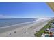 Expansive beach with ocean view, palm trees, and beachgoers at 3500 N Ocean Blvd. # 701 702, North Myrtle Beach, SC 29582