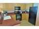 Kitchen with wooden cabinets, black appliances, and dark countertop at 3500 N Ocean Blvd. # 701 702, North Myrtle Beach, SC 29582