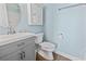Light and airy bathroom featuring a gray vanity, wood floor, and blue walls at 4105 S Ocean Blvd. # 102, North Myrtle Beach, SC 29582