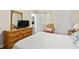 Warm bedroom featuring wood dresser, woven chair, and TV at 4105 S Ocean Blvd. # 102, North Myrtle Beach, SC 29582